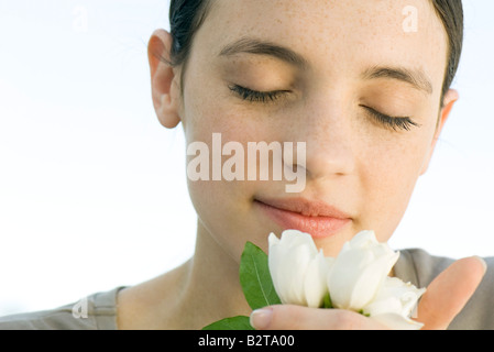 Young woman smelling rose blanc Banque D'Images