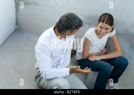 Père et fille assis ensemble, bavarder, high angle view Banque D'Images