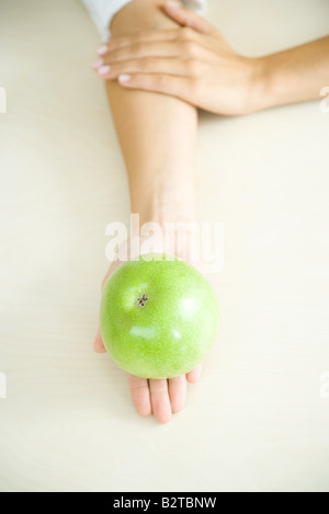 Se reposant dans un Apple woman's palm, high angle view Banque D'Images