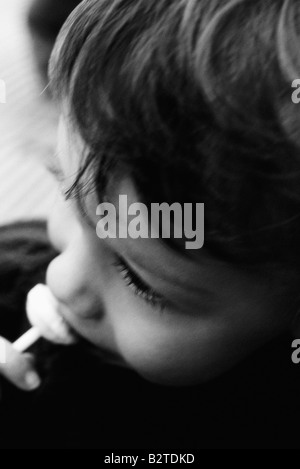 Little Boy eating a sucker, high angle view, cropped Banque D'Images