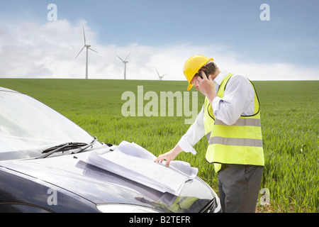 L'homme sur mobile sur une ferme éolienne Banque D'Images