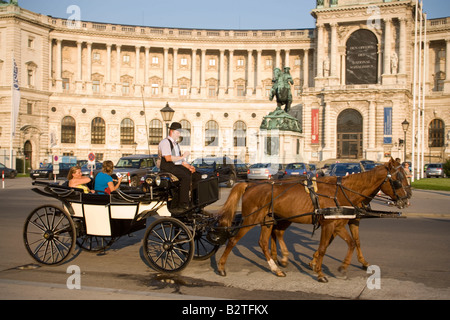 Fiaker passant le Neue Hofburg au cours d'une visite de la ville, Vienne, Autriche Banque D'Images