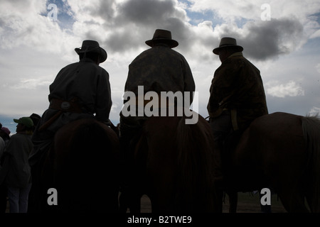 Trois hommes participant à la course de chevaux du festival Naadam près d'Oulan Bataar en Mongolie. Banque D'Images