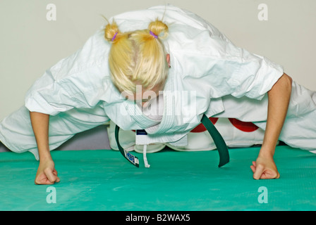 Young woman doing push-ups avec ses poings fermés dans la classe de Karaté Banque D'Images