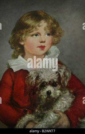 Portrait d'un jeune enfant avec des cheveux d'or en manteau rouge tenant un petit chien blanc fait dans le début des années 40 Banque D'Images