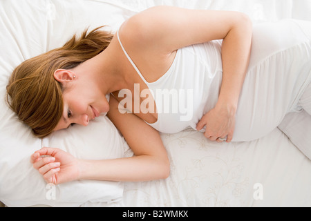 Pregnant woman Lying in Bed smiling Banque D'Images