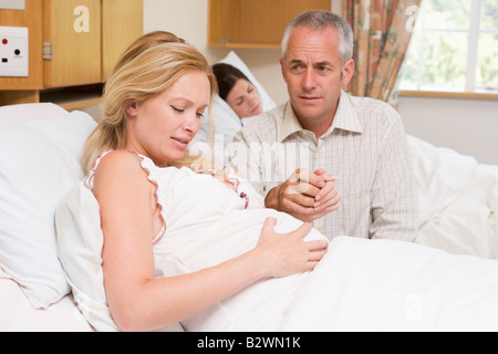 Femme enceinte dans la douleur avec son mari à l'hôpital Banque D'Images