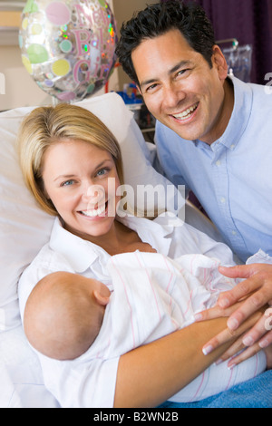 Nouvelle Maman avec bébé et de son mari à l'hôpital, smiling Banque D'Images