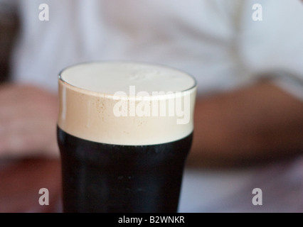 Pinte de Guinness une pinte de Guinness se repose avant de boire sur une table Banque D'Images