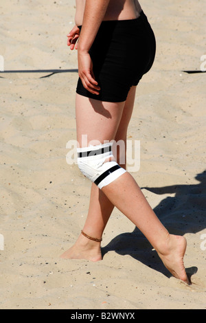 Close up d'un genou bandé d'une femme sur la plage Banque D'Images