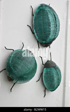 Verre vert Bugs sur un mur blanc trois énormes insectes ramper en verre d'un mur blanc, Fira Santorini Grèce Banque D'Images