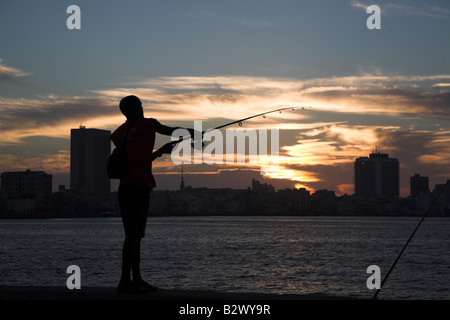 Un jeune pêcheur jette son bâton dans la mer depuis la Le Malecon de La Havane, Cuba. Banque D'Images