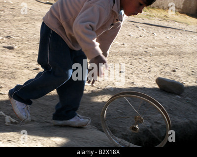 Un enfant joue avec une roue au Pérou, Amérique du Sud Banque D'Images