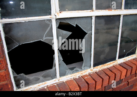 Vitres cassées situé dans le cadre en métal et en brique de bas de châssis. Banque D'Images
