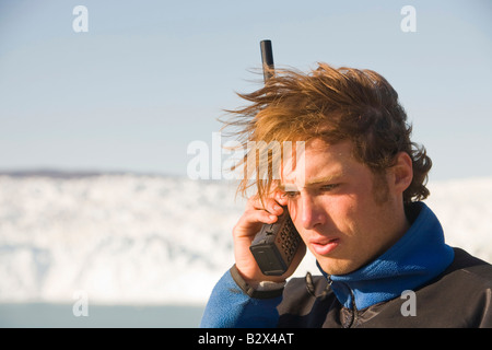 Un guide du Groenland à l'aide d'un téléphone satellite dans une région éloignée au Camp Victor sur Greenlands côte ouest Banque D'Images