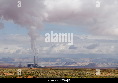 La combustion du charbon électrique émet de la fumée blanche qui atteint jusqu'à rejoindre les nuages blancs moelleux Banque D'Images