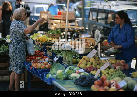 Femme achète des légumes dans un marché en plein air à Rome Italie Banque D'Images