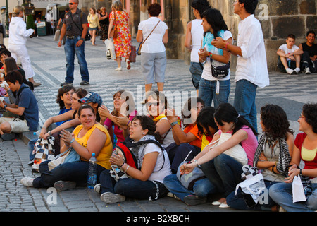 Un groupe de jeunes touristes féminins se sont réunis pour regarder dans la performance impromptue du Prague touristique populaire près de Old Town Hall Banque D'Images