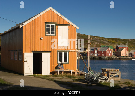 Soirée à Gjaeslingan Vikna, Sør en Norvège. Homme assis sur un banc de nettoyer les petites feuilles de verre. Banque D'Images