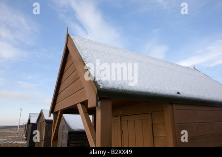 Neige sur cabines de plage en face près de Kingsdown dans le Kent Banque D'Images