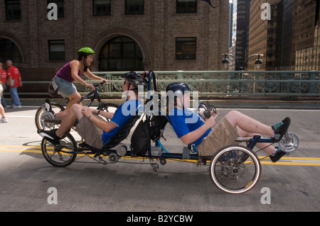 Deux cyclistes sur un vélo tandem en été rues. Banque D'Images