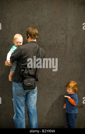 Le père et ses deux enfants à la recherche lors de l'exposition 'promenade' par sculpteur américain Richard Serra. Banque D'Images