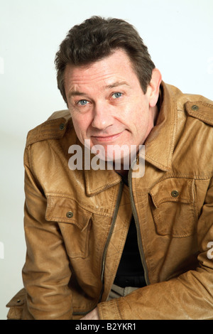 L'homme dans son 40s smiling portant une veste en cuir Banque D'Images