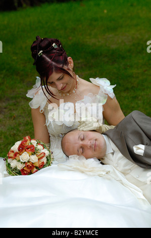 Couple avec mari endormi sur sa femme dans le banc de parc, France Banque D'Images