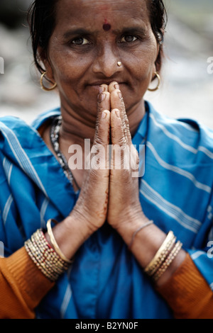 Un hindou, Indien femme portant un sari coloré et bijoux décoratifs détient ses mains ensemble dans une prière. Banque D'Images