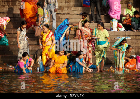 Une foule de femmes indiennes vêtues de saris colorés se baignent dans le Gange. Banque D'Images