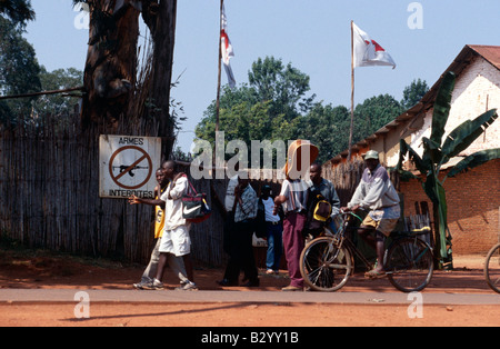 Les gens passent devant un panneau interdisant l'feu au Burundi. Banque D'Images