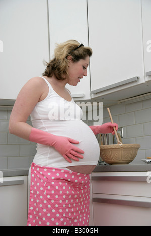 Pregnant Woman Baking in Kitchen Banque D'Images