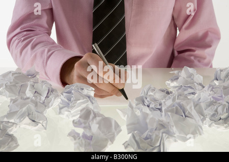 Businessman entouré de papier froissé Banque D'Images