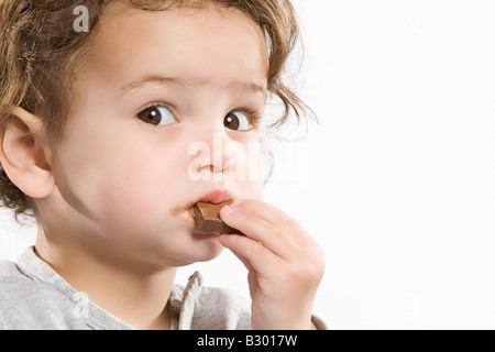 Little Girl Eating Chocolate Banque D'Images