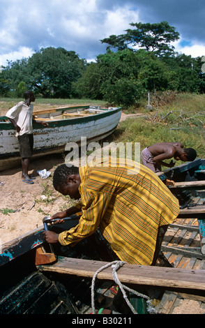 Carpenter la réparation de bateau en bois sur le lac Malawi, Malawi, Afrique Banque D'Images