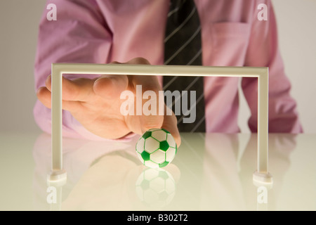Businessman jouer avec Football Miniature Banque D'Images
