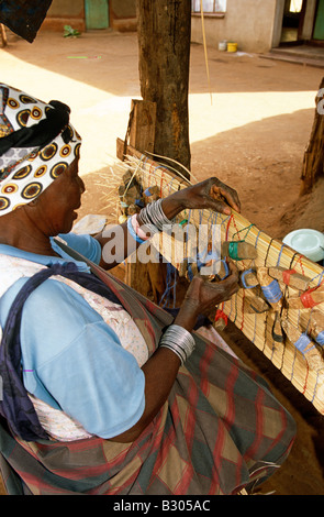 Femme tissant le tapis de village. L'Afrique du Sud. Banque D'Images