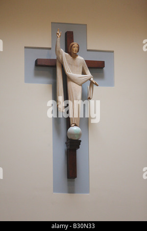 Un crucifix avec Jésus est suspendu sur le mur de façade de la nef d'une église catholique. Banque D'Images