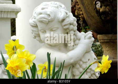 Sculpture ange enfant avec des raisins et des fleurs au printemps de la jonquille Banque D'Images