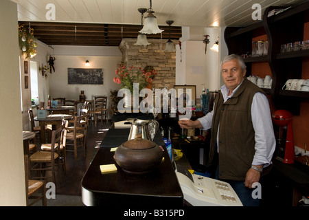 L'Épire Grèce Zagororia Megalo Papigko village intérieur d'une taverne locale le propriétaire derrière le bar Banque D'Images