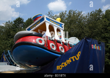 Rocking Tug carnival fête foraine ride. Grand bateau remorqueur face vers la gauche et la moitié en dehors de la piste comme il se transforme en swing. Banque D'Images