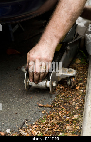 Un homme travaillant sur une voiture, au Royaume-Uni. Banque D'Images