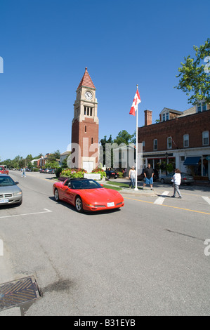 Une Corvette rouge durs par le monument tour de l'horloge à Niagara-on-the-Lake, Ontario. Banque D'Images