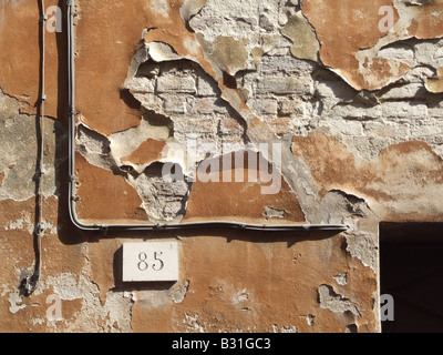 L'écaillement de peinture orange sur l'ancienne propriété mur dans Street Banque D'Images