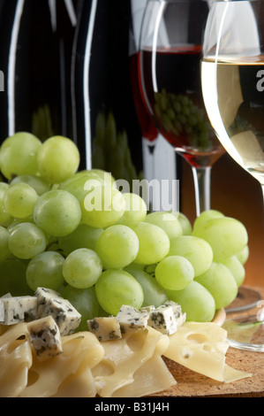 Nature morte avec du fromage vin rouge et blanc sur le fond noir Banque D'Images