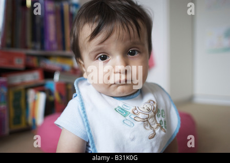 Portrait de 8 mois bébé garçon assis sur le plancher Banque D'Images