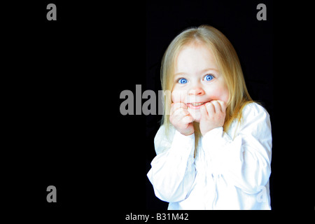 Jolie petite fille avec une expression de peur ou de surprise. Banque D'Images