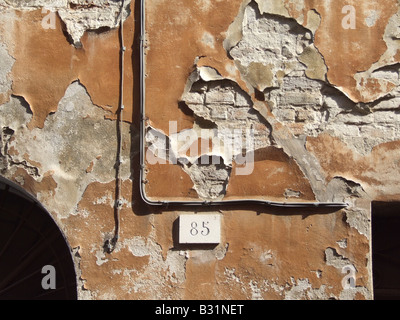 L'écaillement de peinture orange sur l'ancienne propriété mur dans Street Banque D'Images