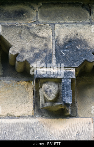 Détail de la frise du mur sud corbel sculptée de millstone grit local avec les grotesques chefs St John the Baptist Church Adel Banque D'Images