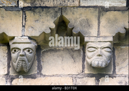 Détail de la frise du mur sud corbel sculptée de millstone grit local avec les grotesques chefs St John the Baptist Church Adel Banque D'Images